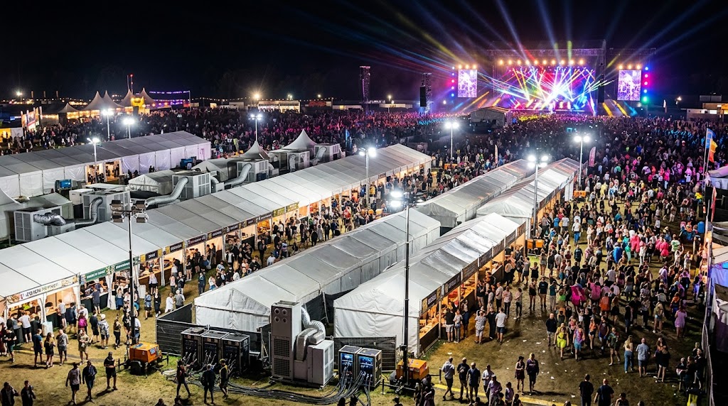 Large-scale outdoor event venue with lighting and temporary infrastructure